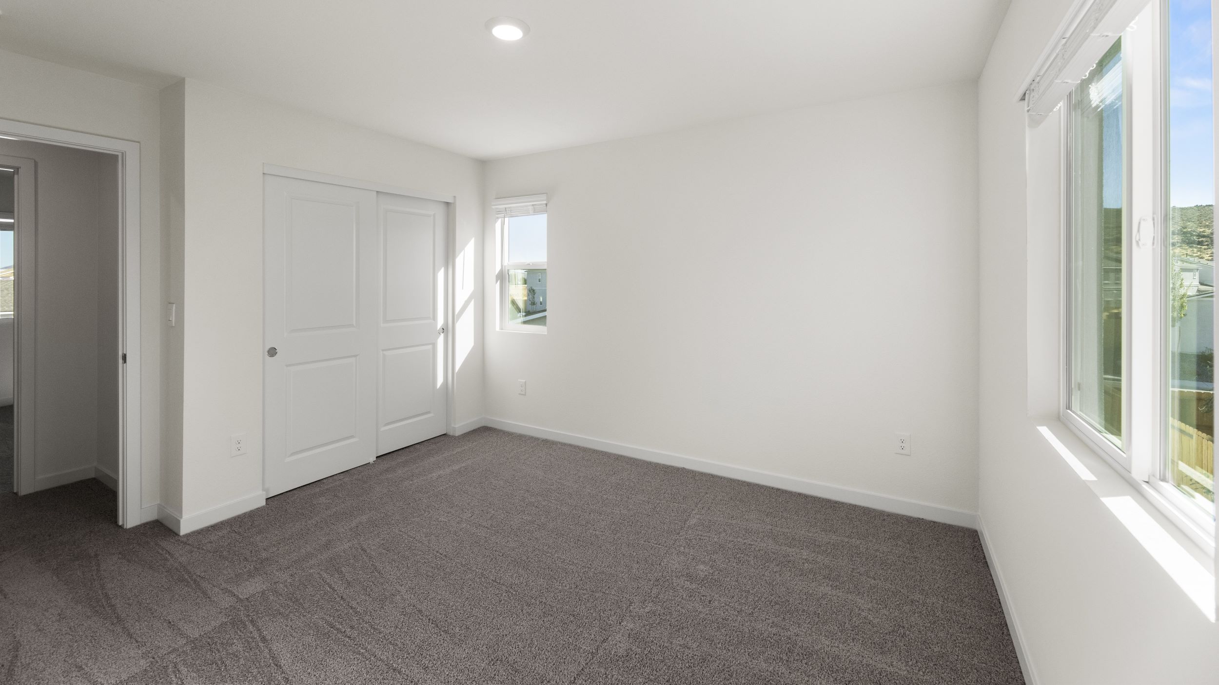 Primary bedroom with carpeted floor and attached bathroom