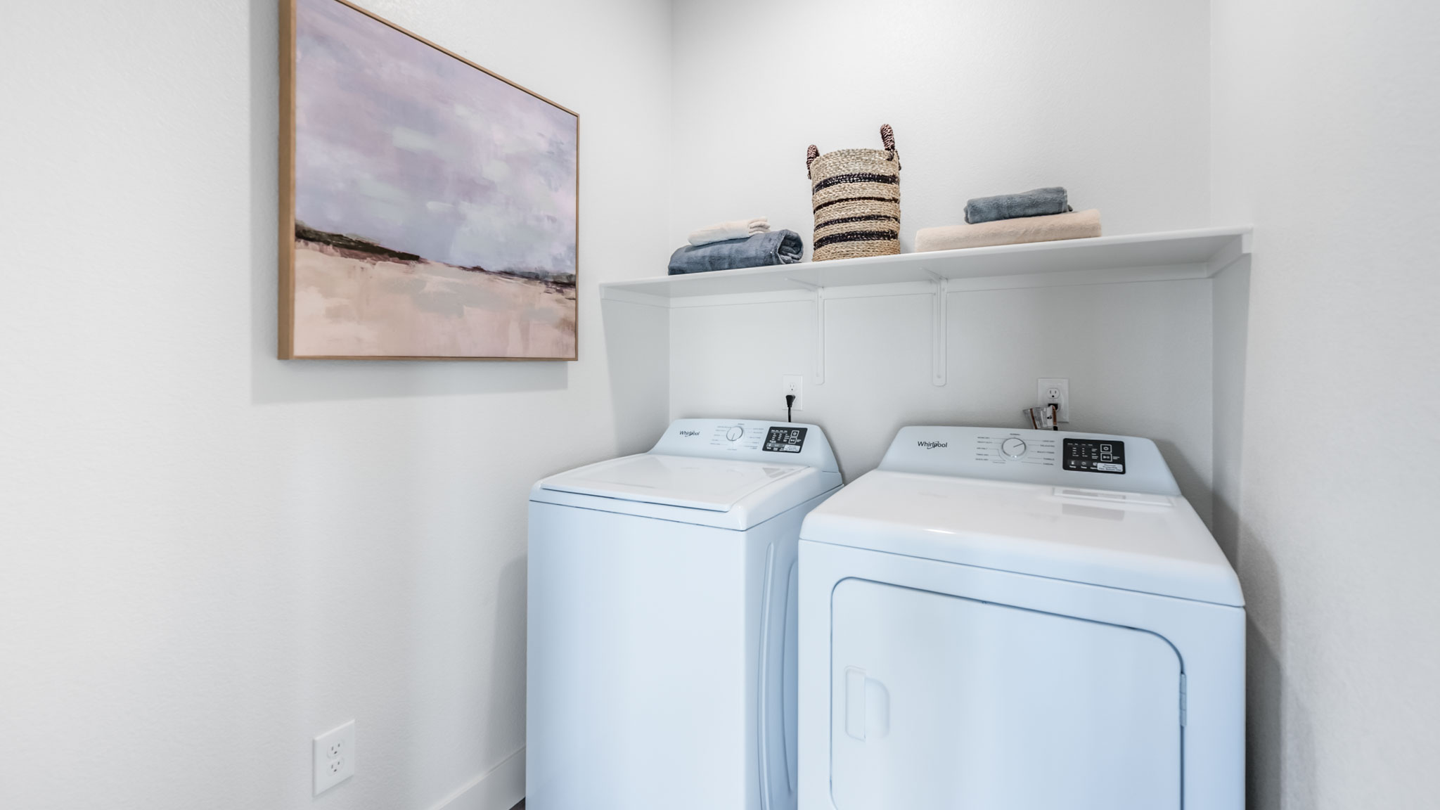 Laundry room with washer and dryer with shelving