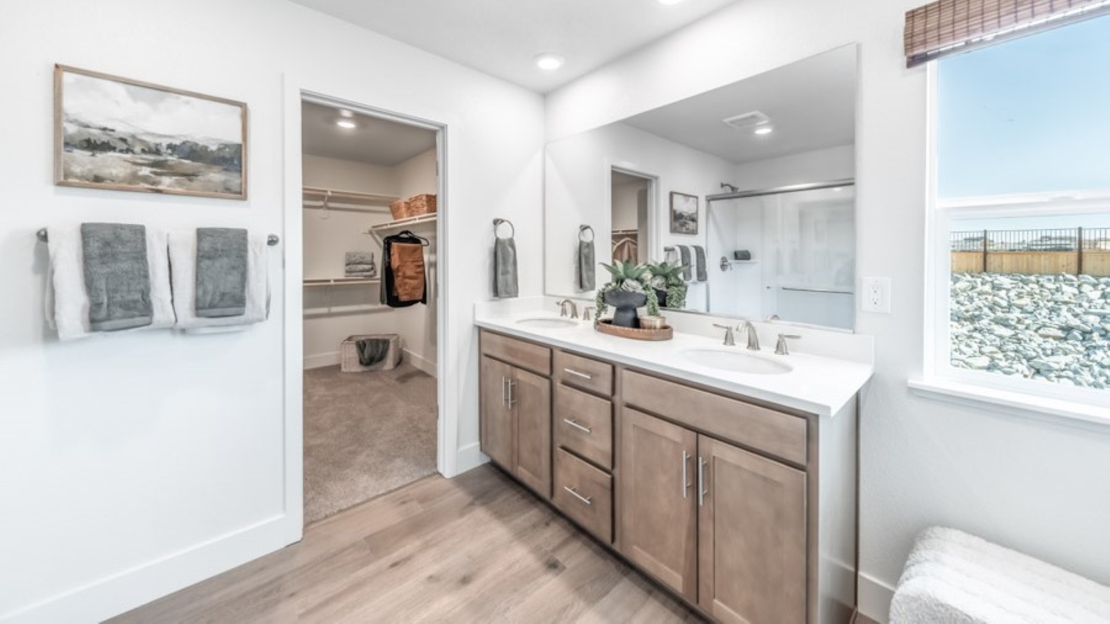 Primary bathroom with double vanity and large window to keep the room bright