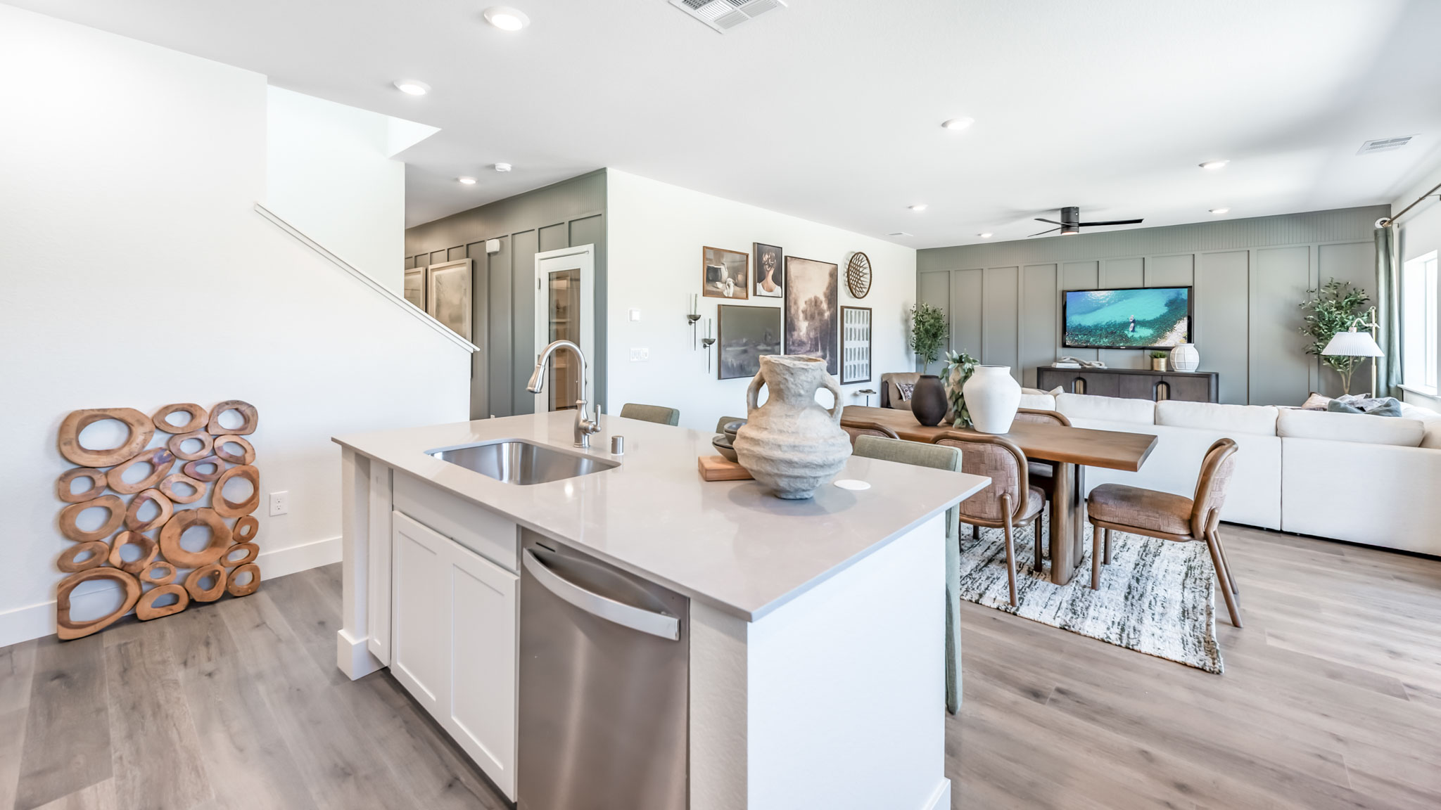 Kitchen island with built-in sink and dishwasher looking out onto dining and living area
