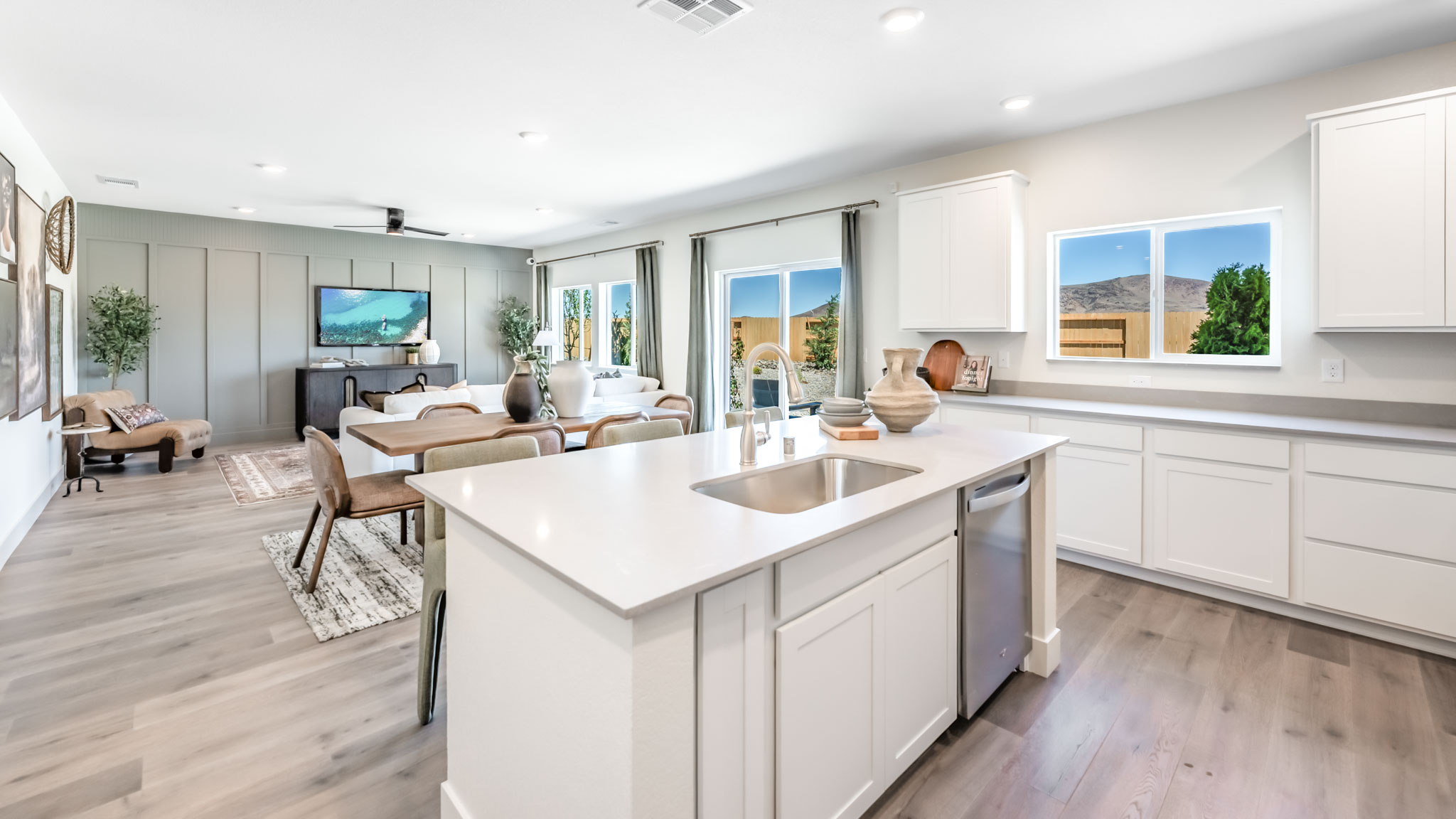 Kitchen island with built-in sink and dishwasher looking out onto dining and living area
