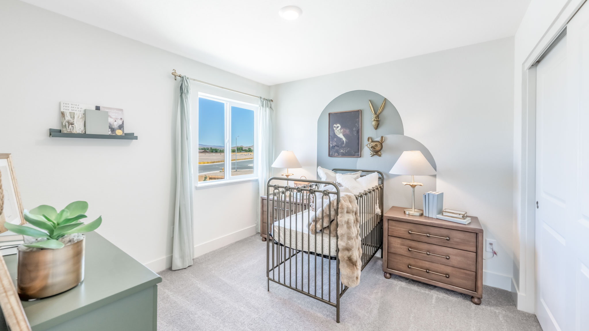 Nursery with carpet and large window letting in bright light