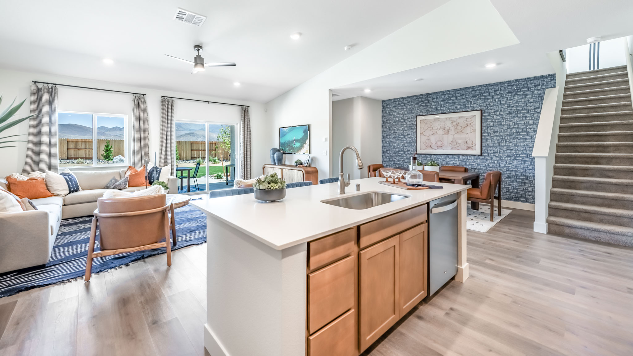 Kitchen island with built-in sink and dishwasher looking out onto dining and living area