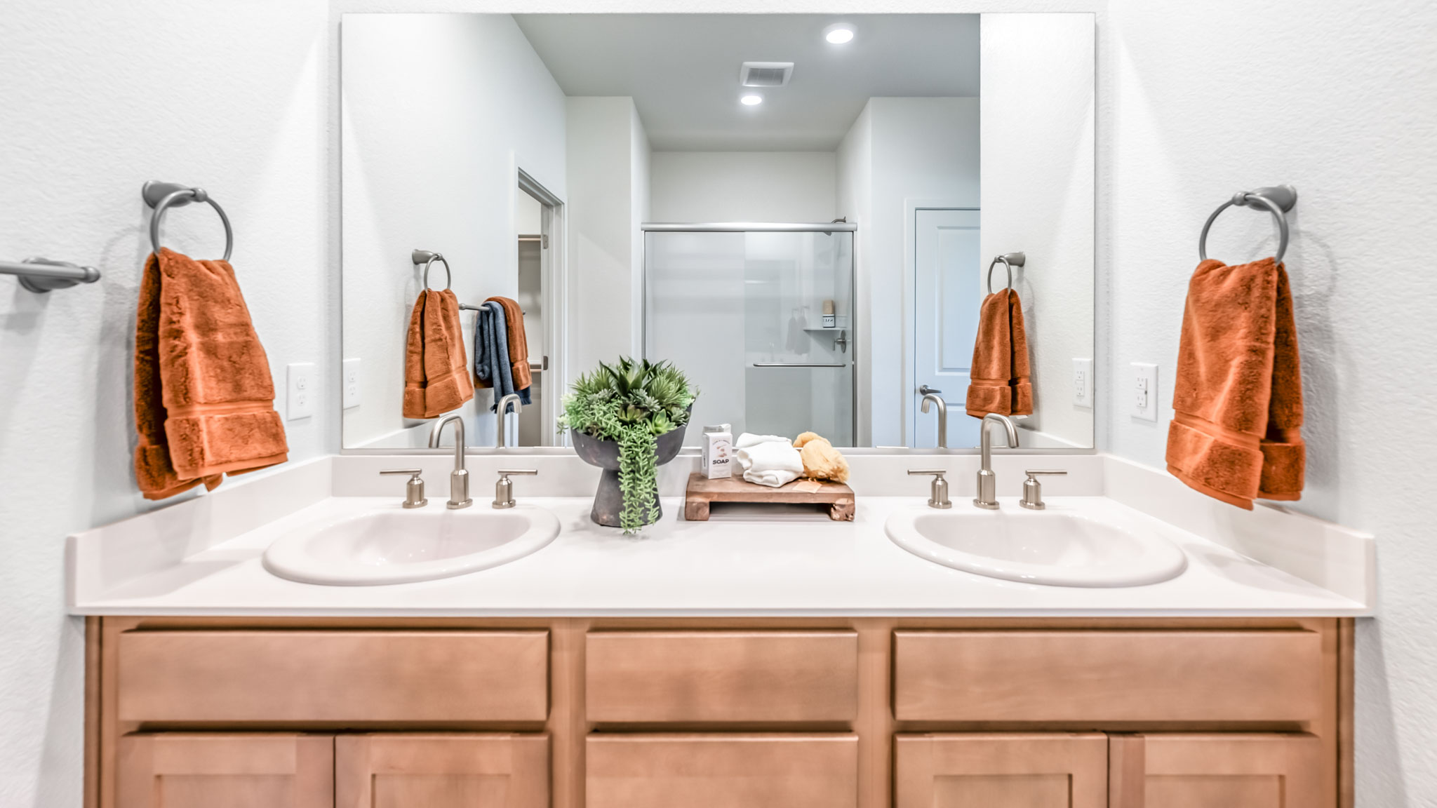 Double vanity in primary bathroom with built-in mirror