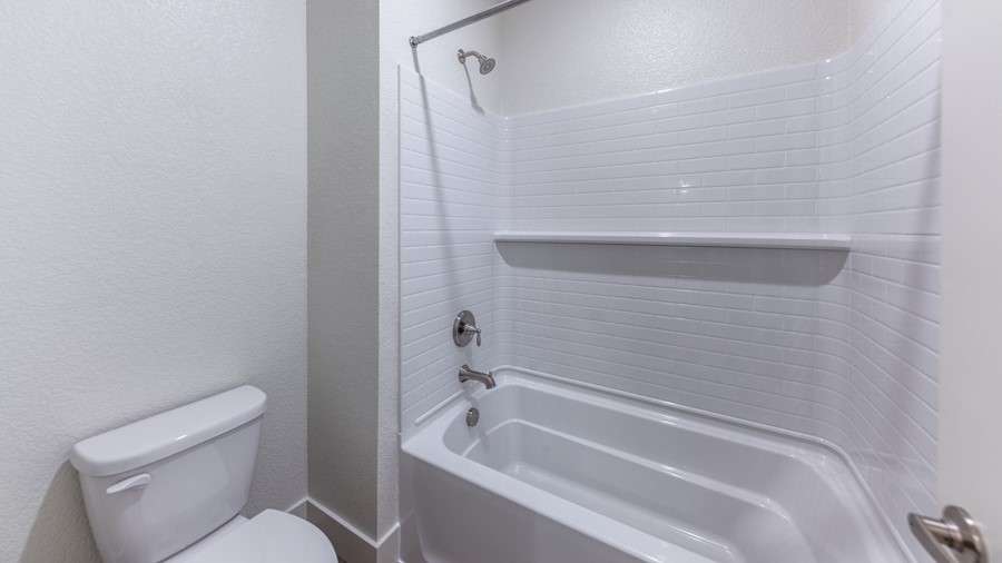 Secondary bathroom with bath and shower combo with toilet