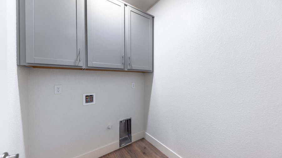 Laundry room with cabinets over full-sized washer and dryer