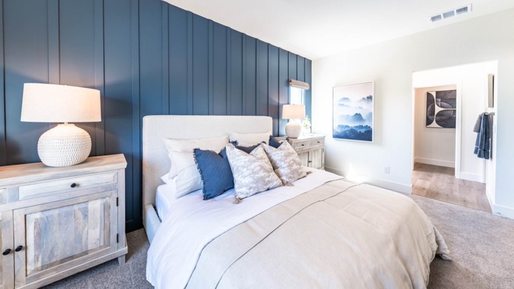 Bright primary bedroom with a king sized bed and carpeted floors