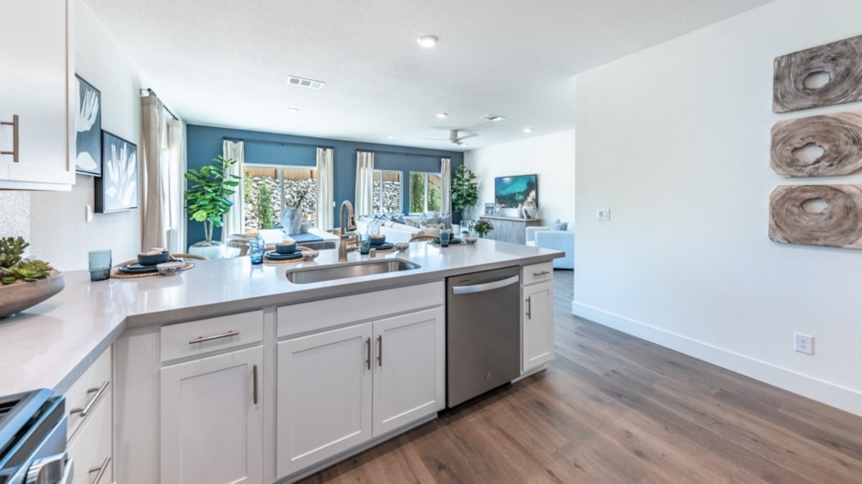 Kitchen with an L shaped island, white shaker-style cabinets and stainless steel appliances
