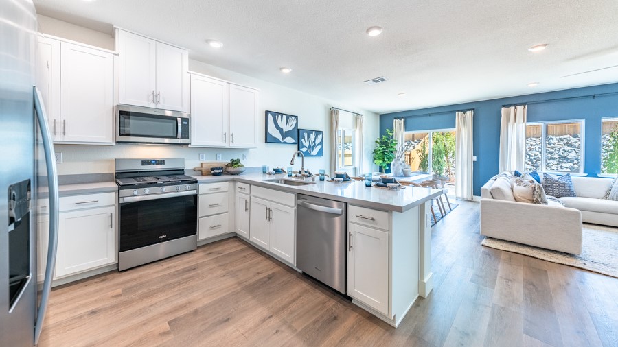 Spacious kitchen featuring a L shape island with built-in dishwasher and sink
