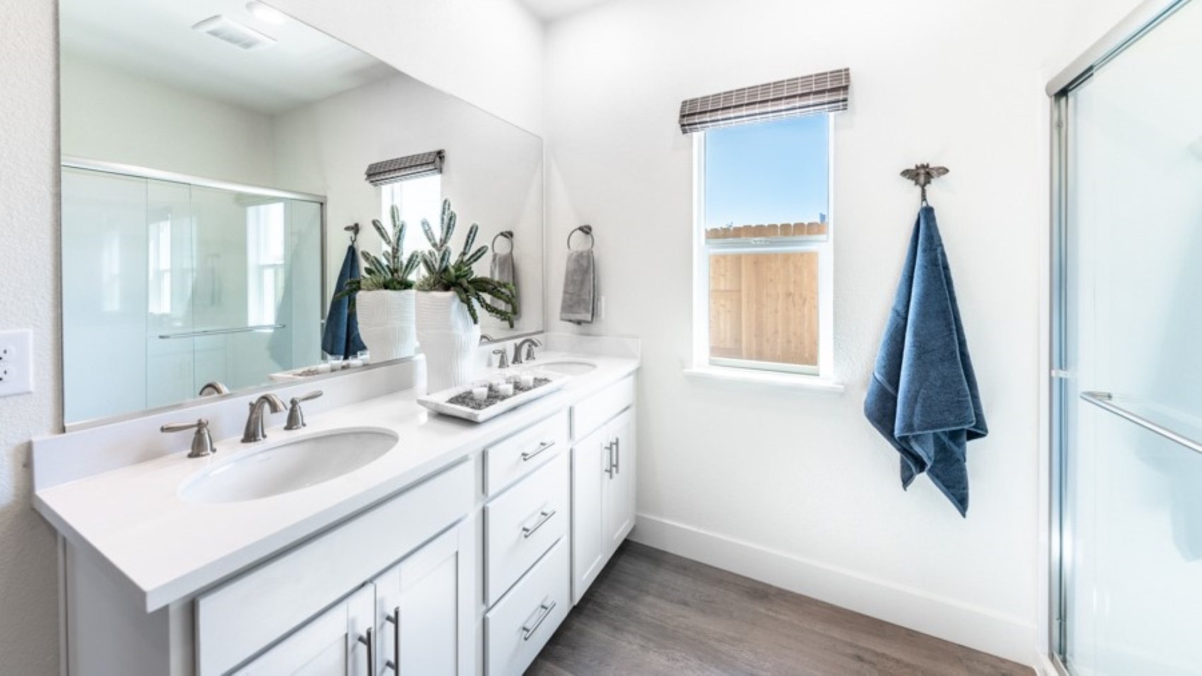 Primary bathroom double vanity next to small window