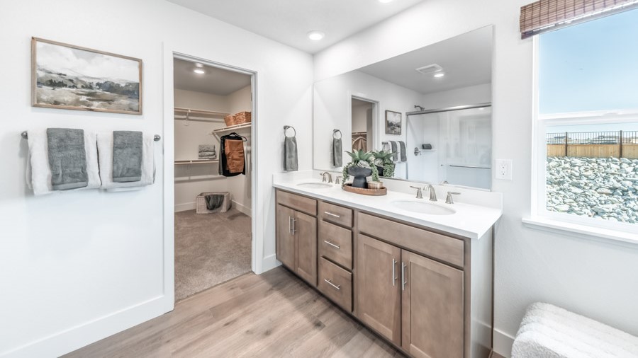 Primary bathroom with double vanity and large window to keep the room bright
