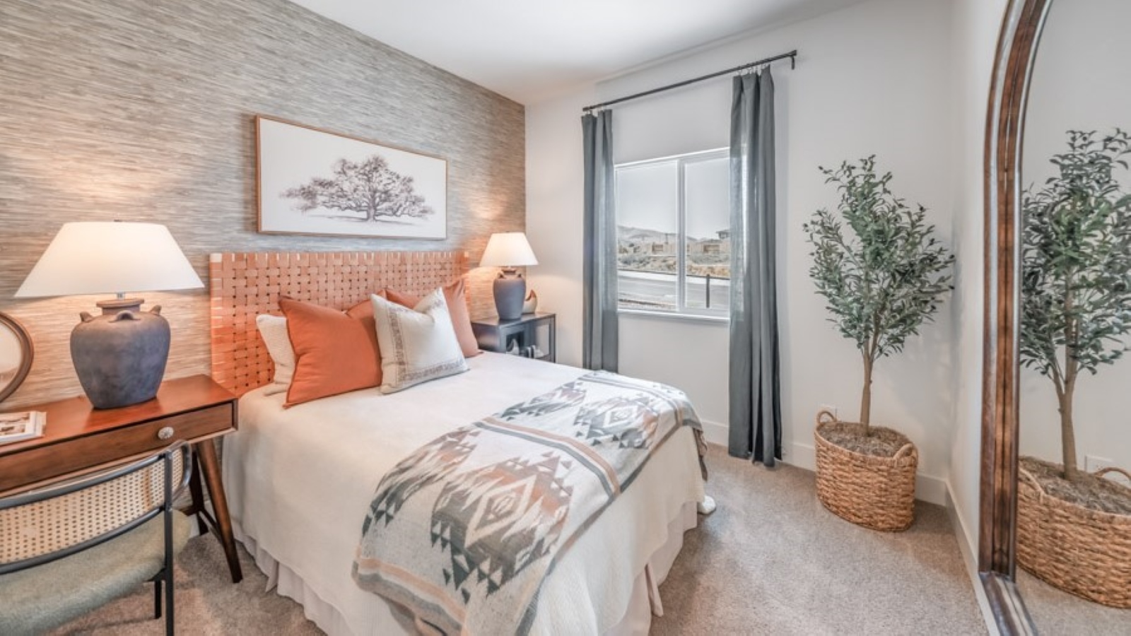 Bedroom on first floor of the home with carpeted floor and a large window