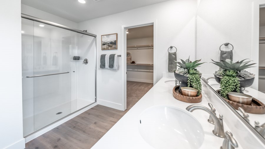Walk-in shower in the primary bathroom next to large walk-in closet