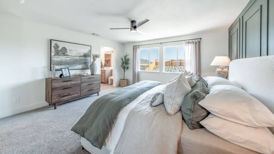 Carpeted primary bedroom with large windows and attached bathroom