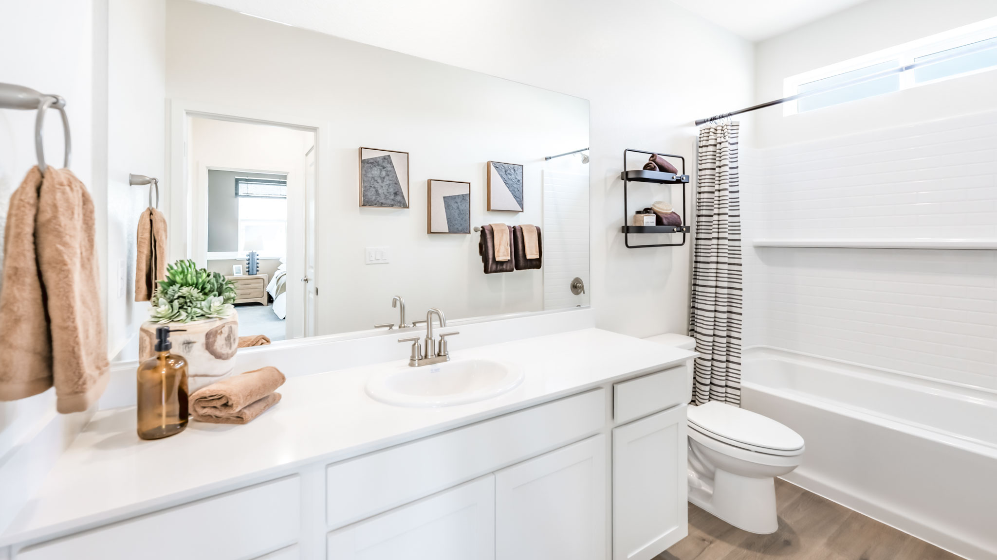 Secondary bathroom with a large vanity, toiler, and shower tub combo