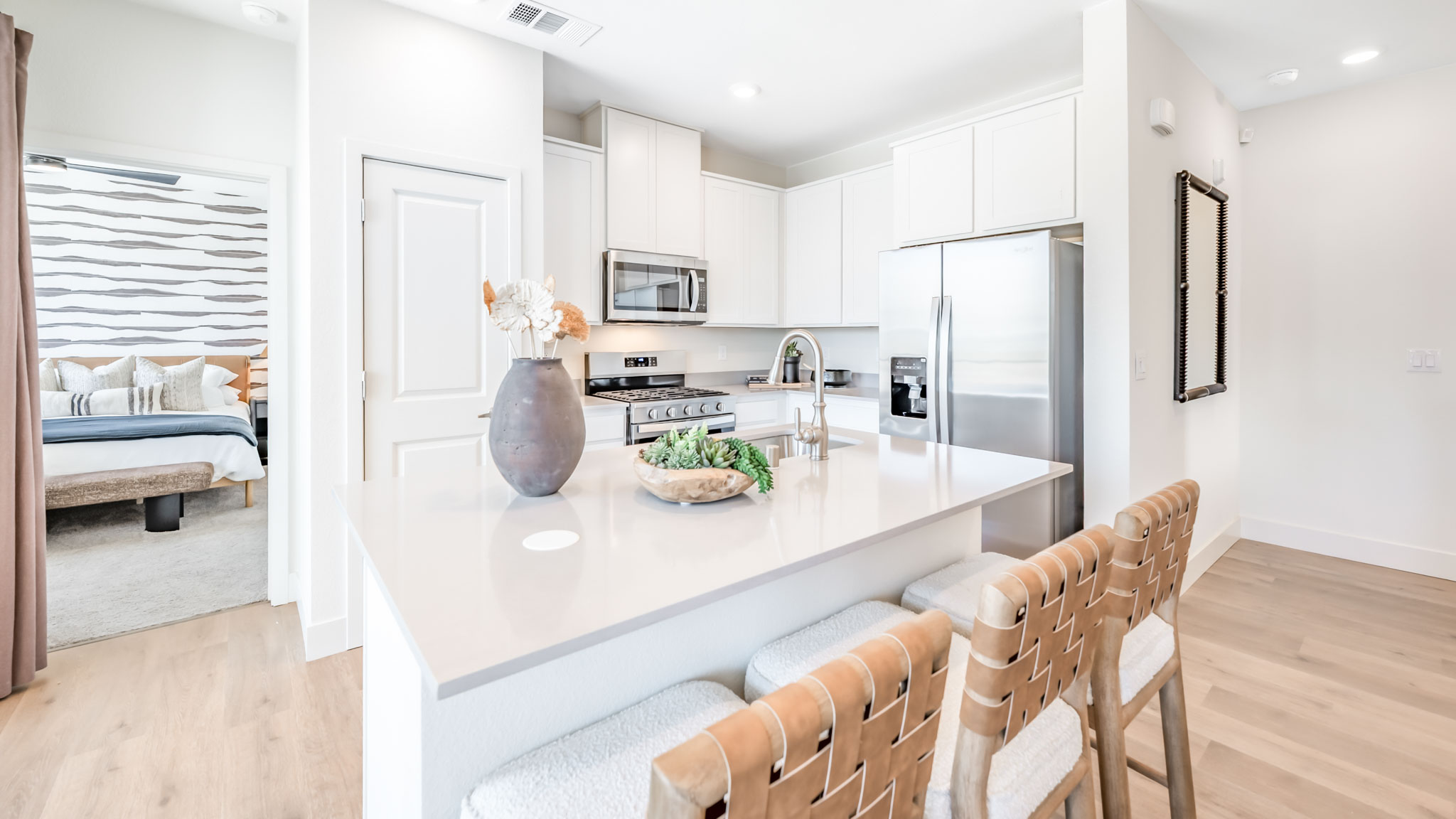 Kitchen island facing cabinets and stainless steel appliances