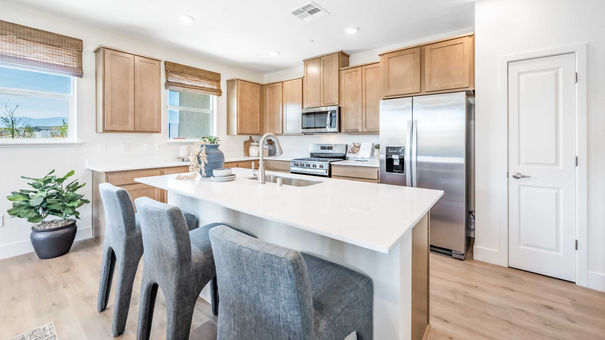 Large kitchen island looking towards the pantry and window above the sink