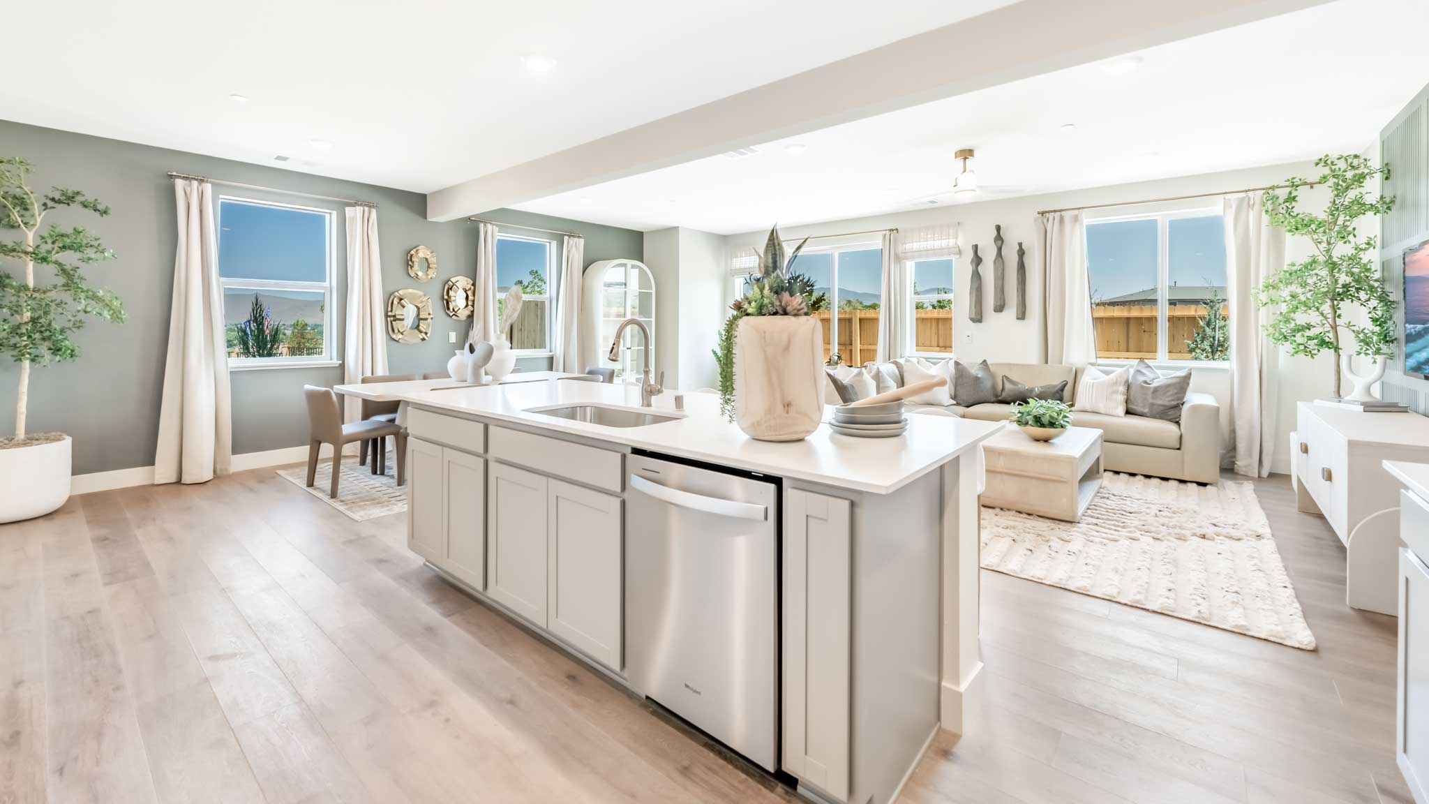 Kitchen island looking out towards a bright great room with a lot of windows