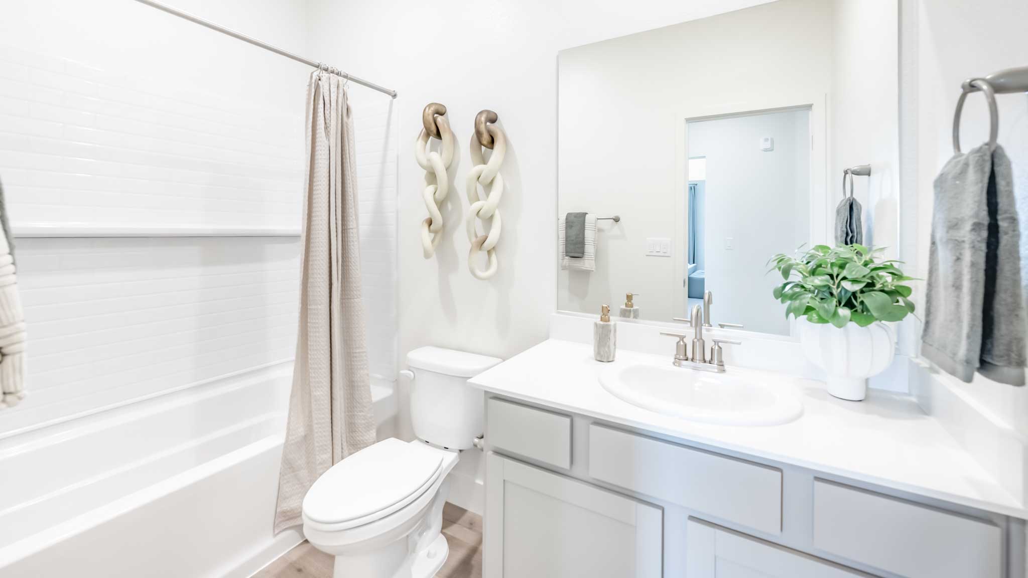 Secondary bathroom with a vanity, toilet, and shower tub combo