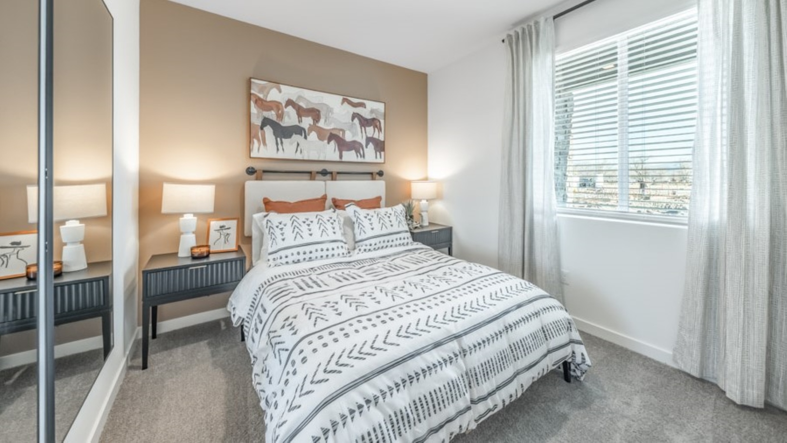 Bedroom with large window letting in bright light and carpeted floors on the first floor