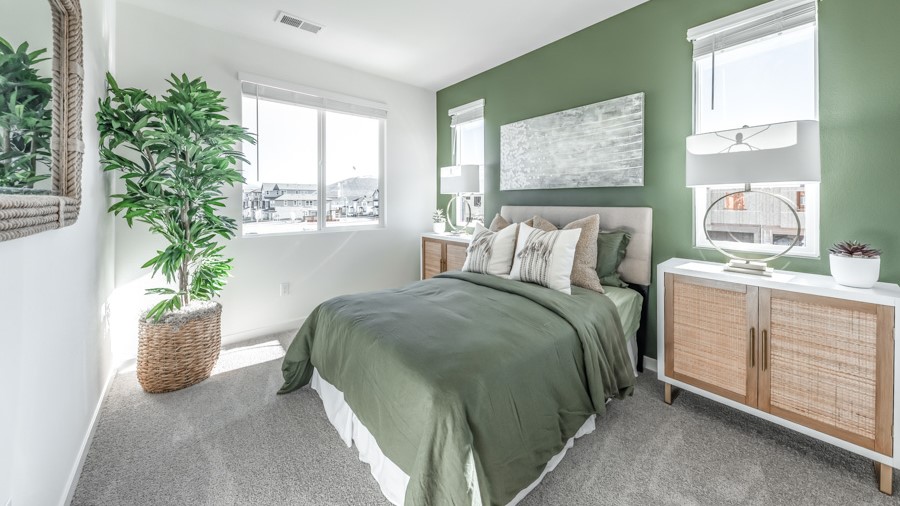Bedroom with large window letting in bright light and carpeted floors