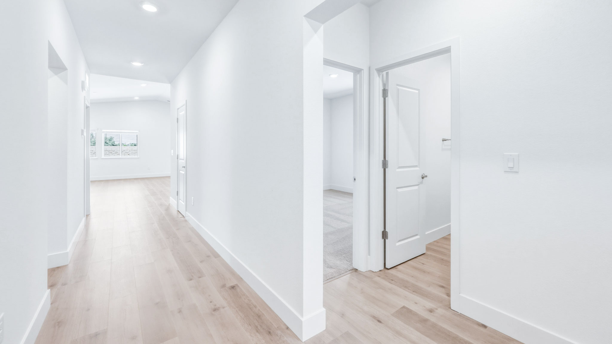Hallway entry with bedrooms and a full bathroom to the right