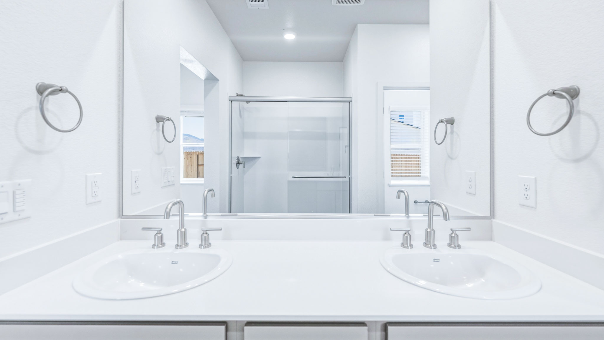 Primary bathroom with dual sinks and a large mirror