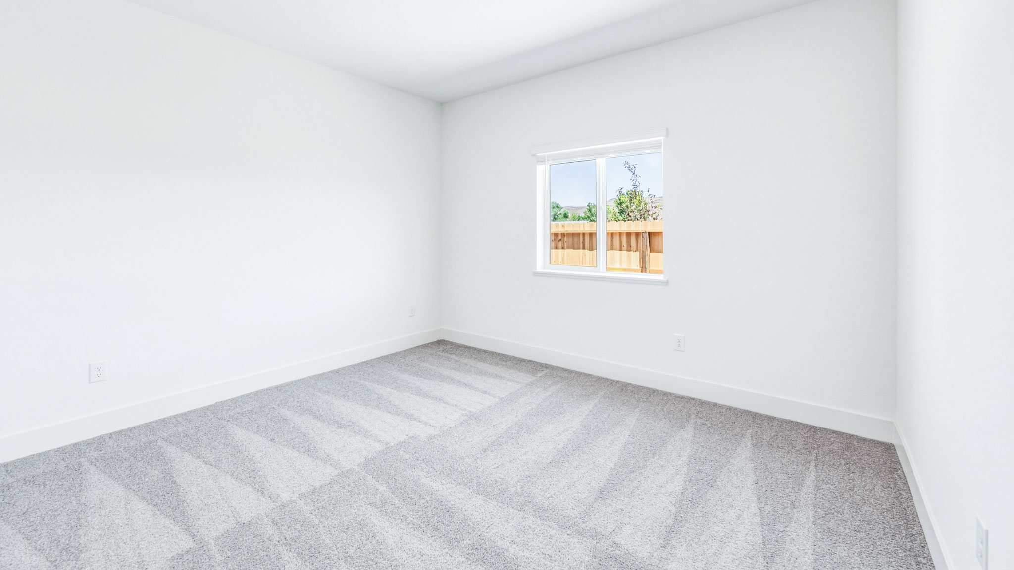 Secondary carpeted bedroom with bright light