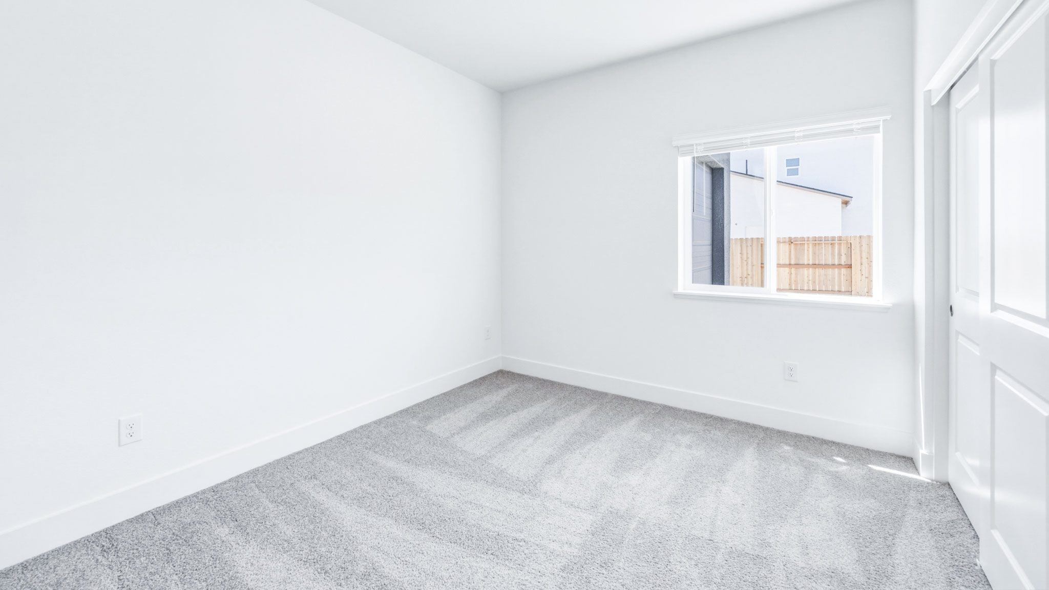 Secondary carpeted bedroom with bright light