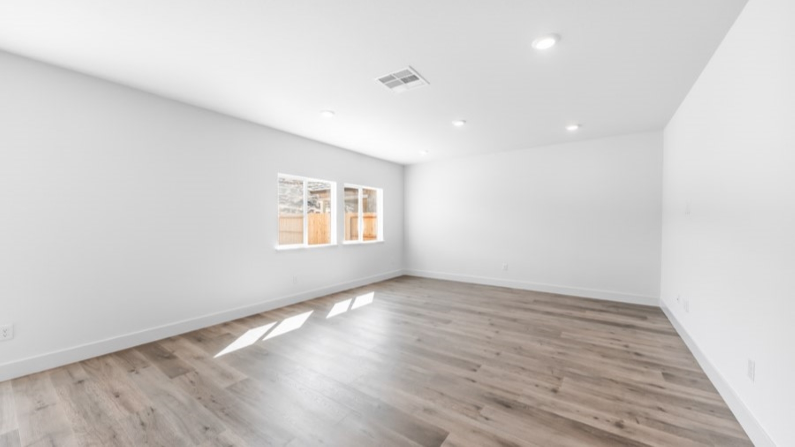 Living room with space for a large sectional couch and large bright windows