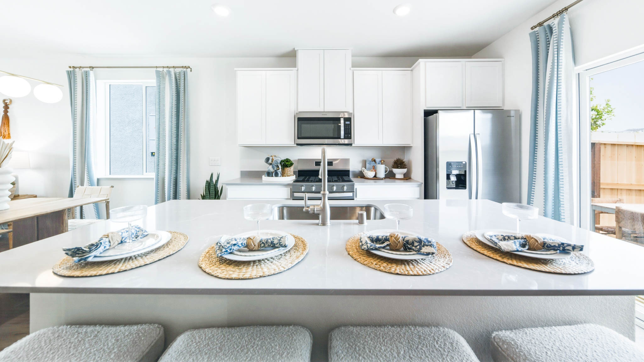 Kitchen island looking towards the kitchen sink, cabinets, and stainless steel appliances