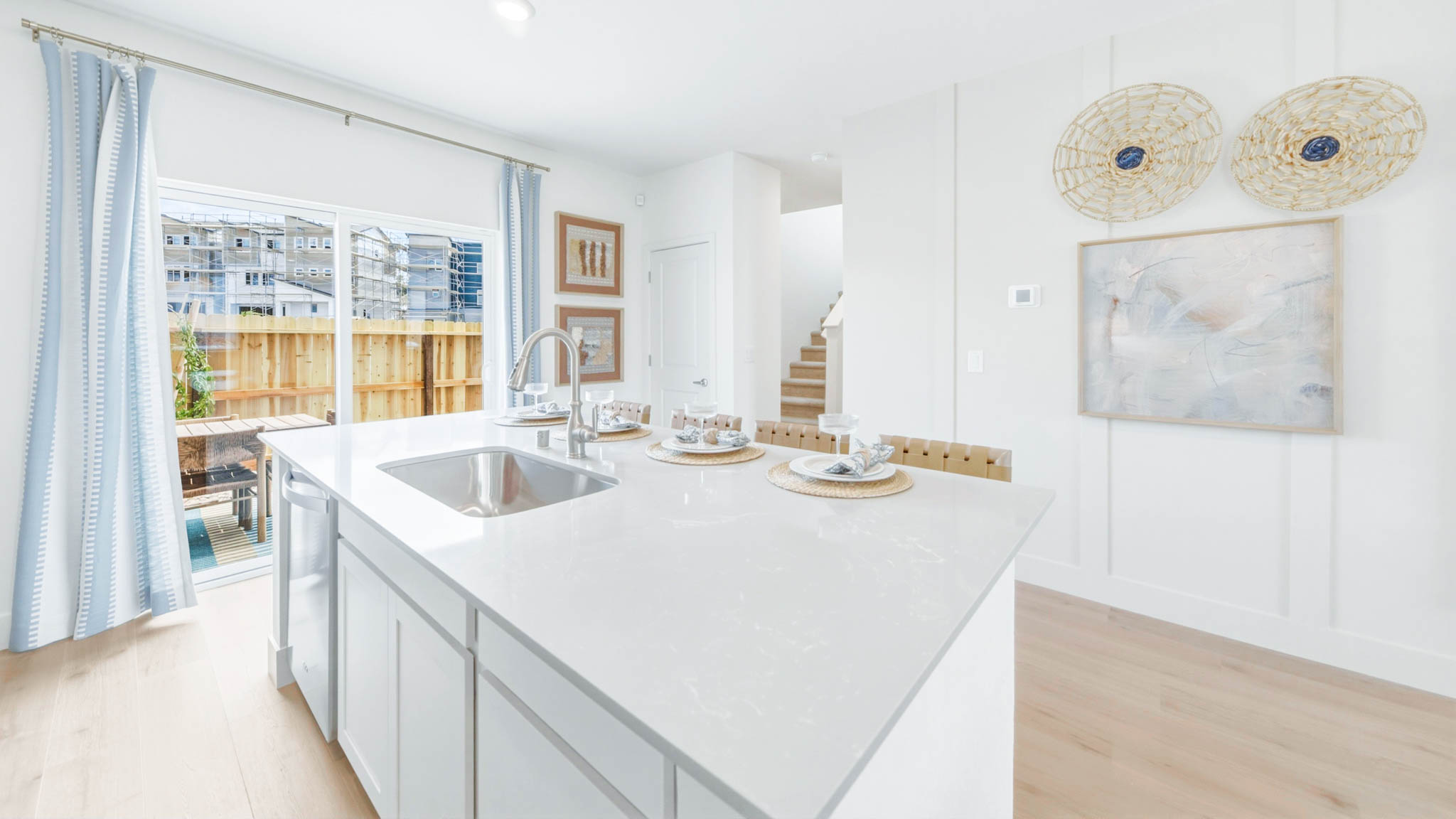 Kitchen island with dishwasher and sink looking towards the sliding backyard door