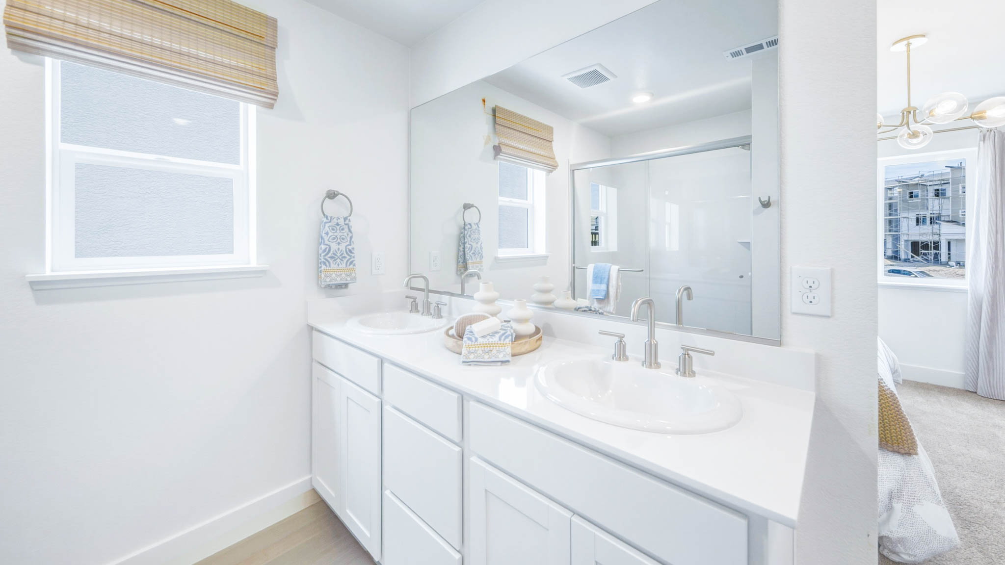 Primary bedroom with a dual vanity and large window