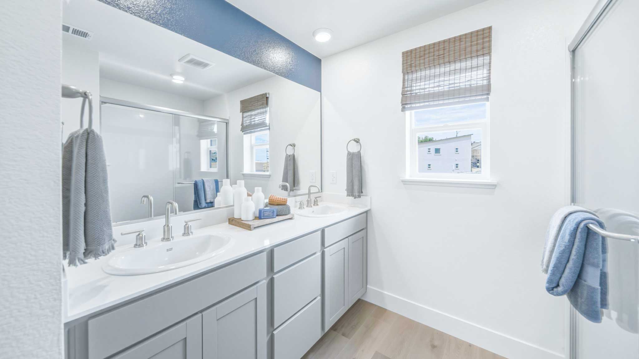 Primary bathroom with dual vanity and a window