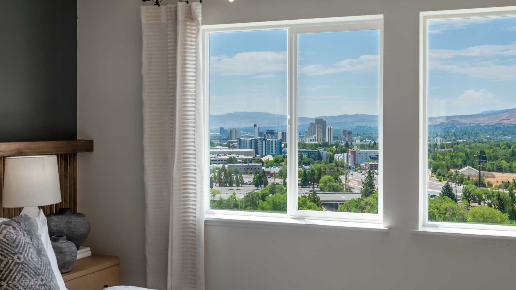 Large windows in the primary bedroom looking out towards downtown Reno