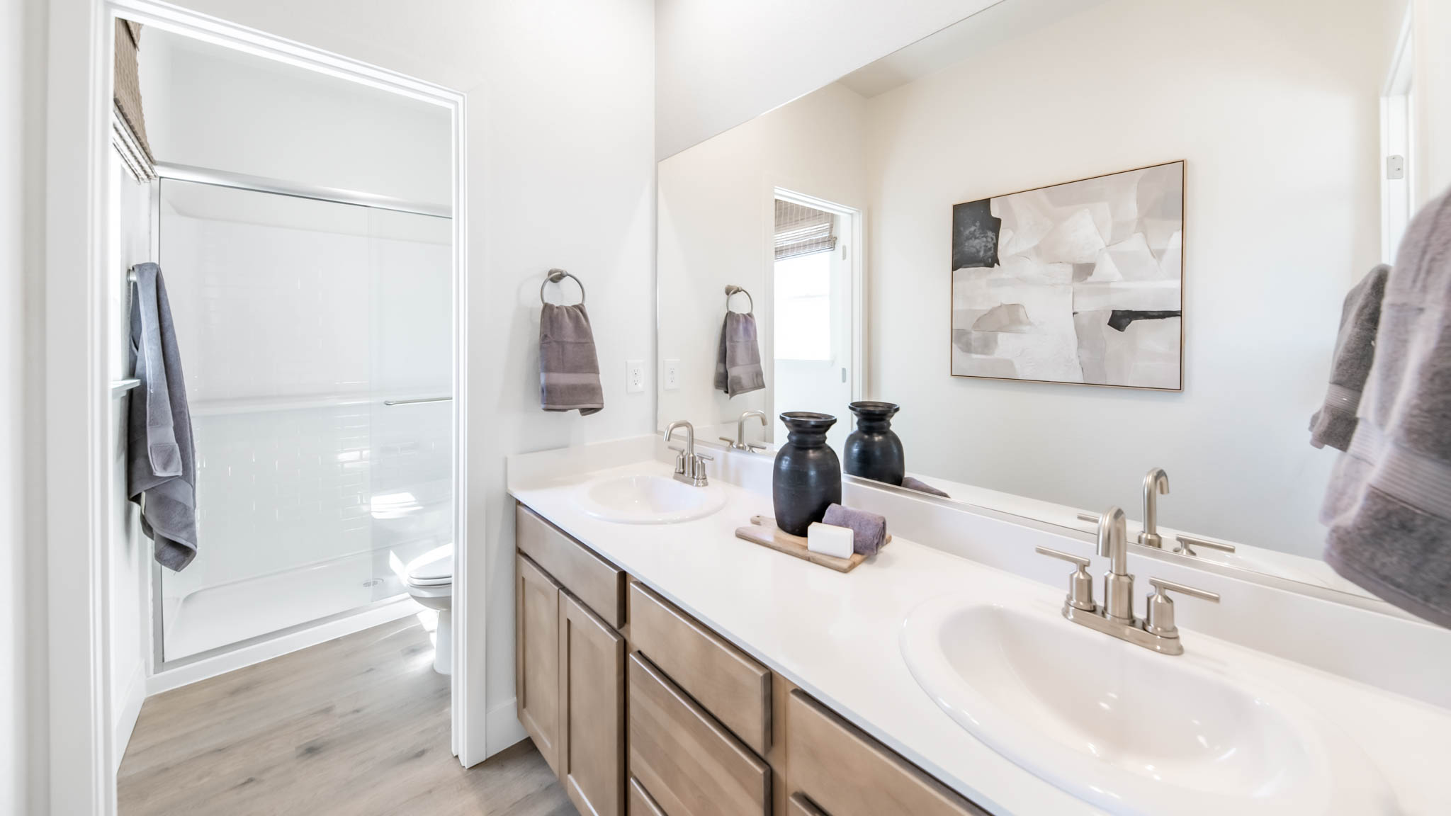 Secondary bathroom with a dual vanity and separate room for a toilet and shower