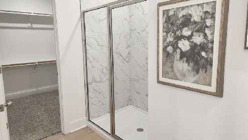 Primary bathroom with large shower with sliding glass doors
