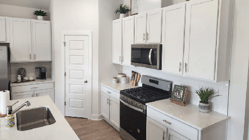 Kitchen with gas stove and white cabinets