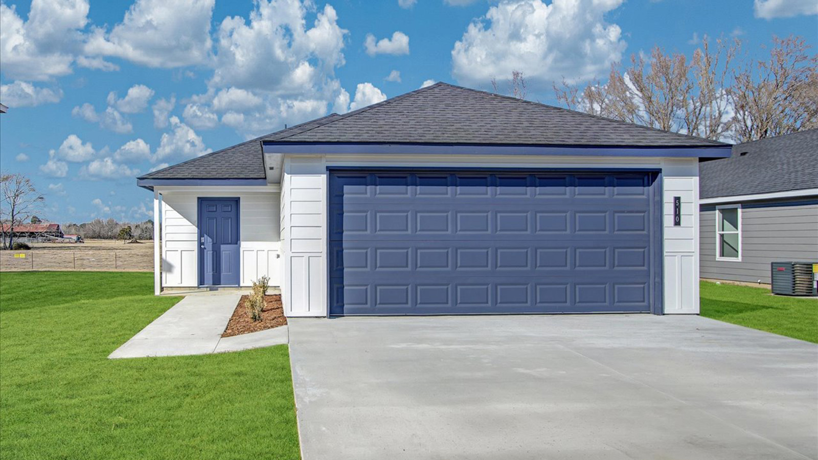 Single story home with white siding and blue 2 car garage