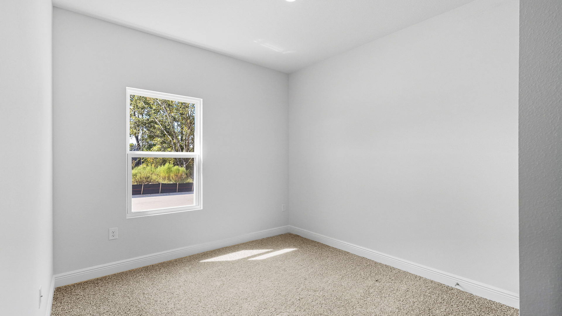 The Creekside floorplan guest bedroom three with carpet throughout