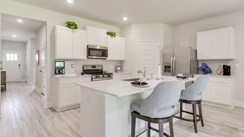 The Beau floorplan kitchen with white shaker cabinets and quartz countertops
