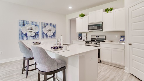 The Beau floorplan kitchen with stainless-steel appliances with EVP flooring throughout
