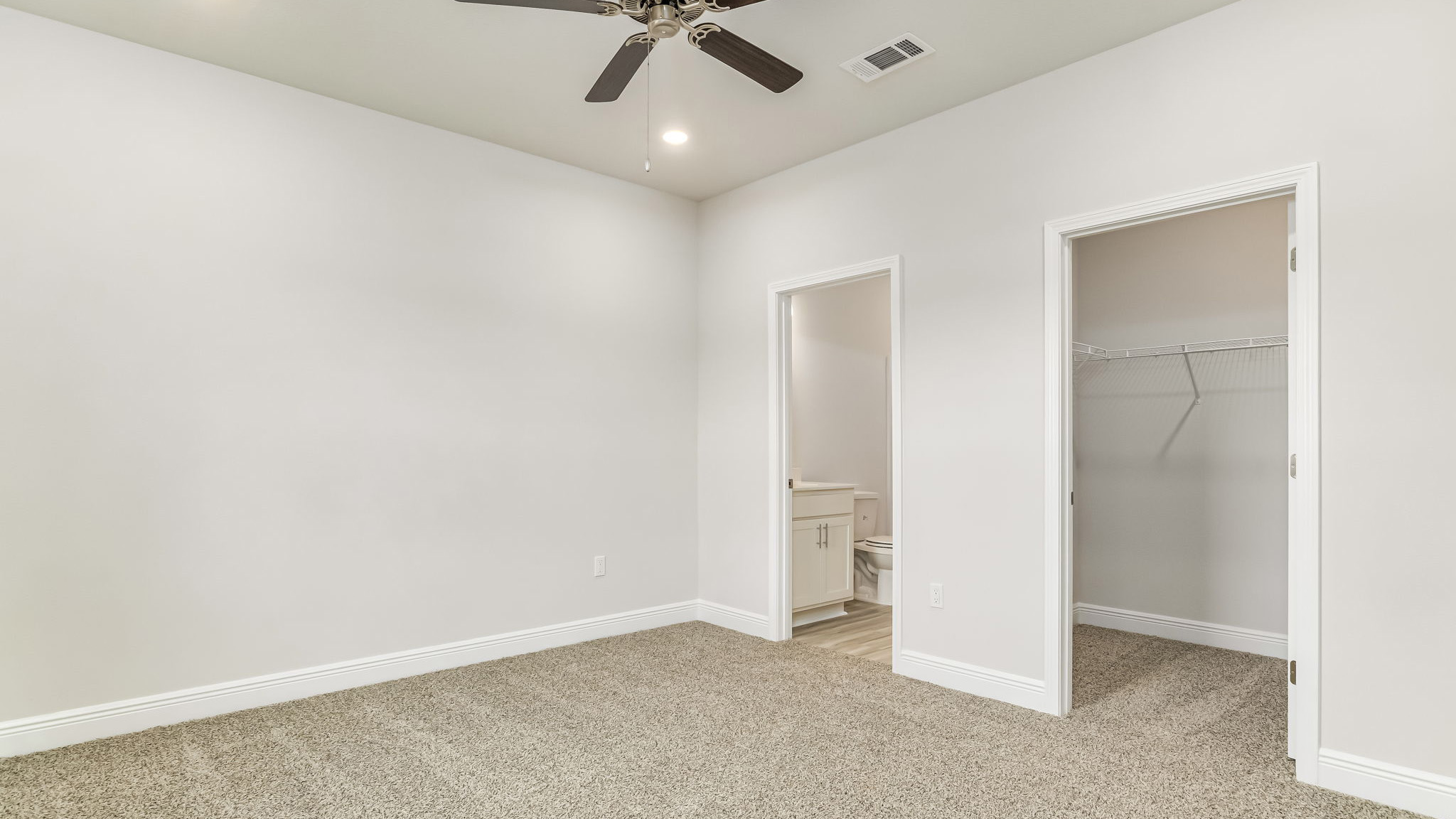 The Delilah primary bedroom with carpet throughout