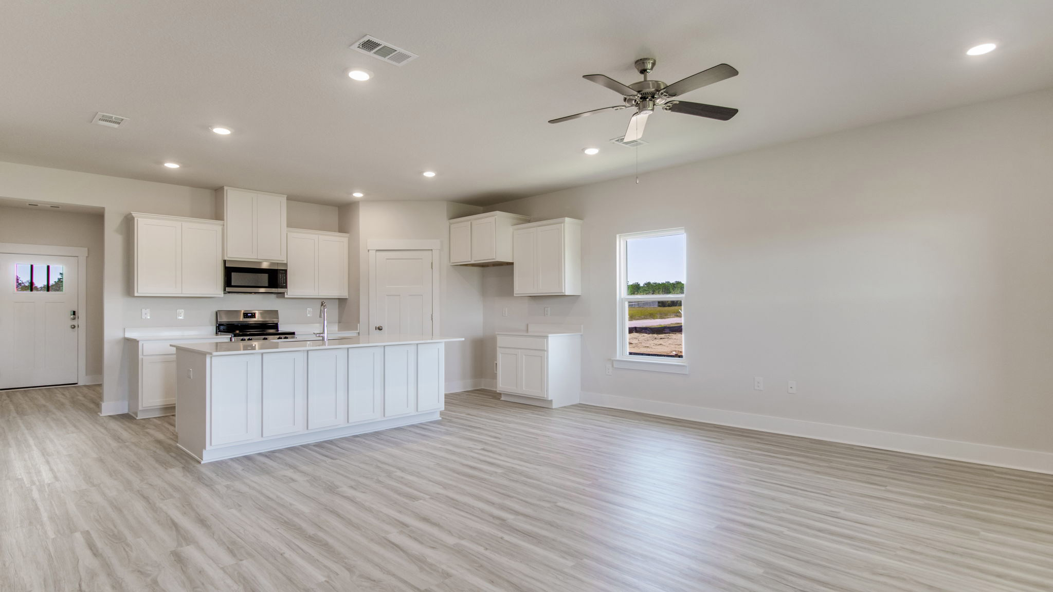 The Ozark floorplan open concept kitchen, dining and living room with EVP flooring throughout