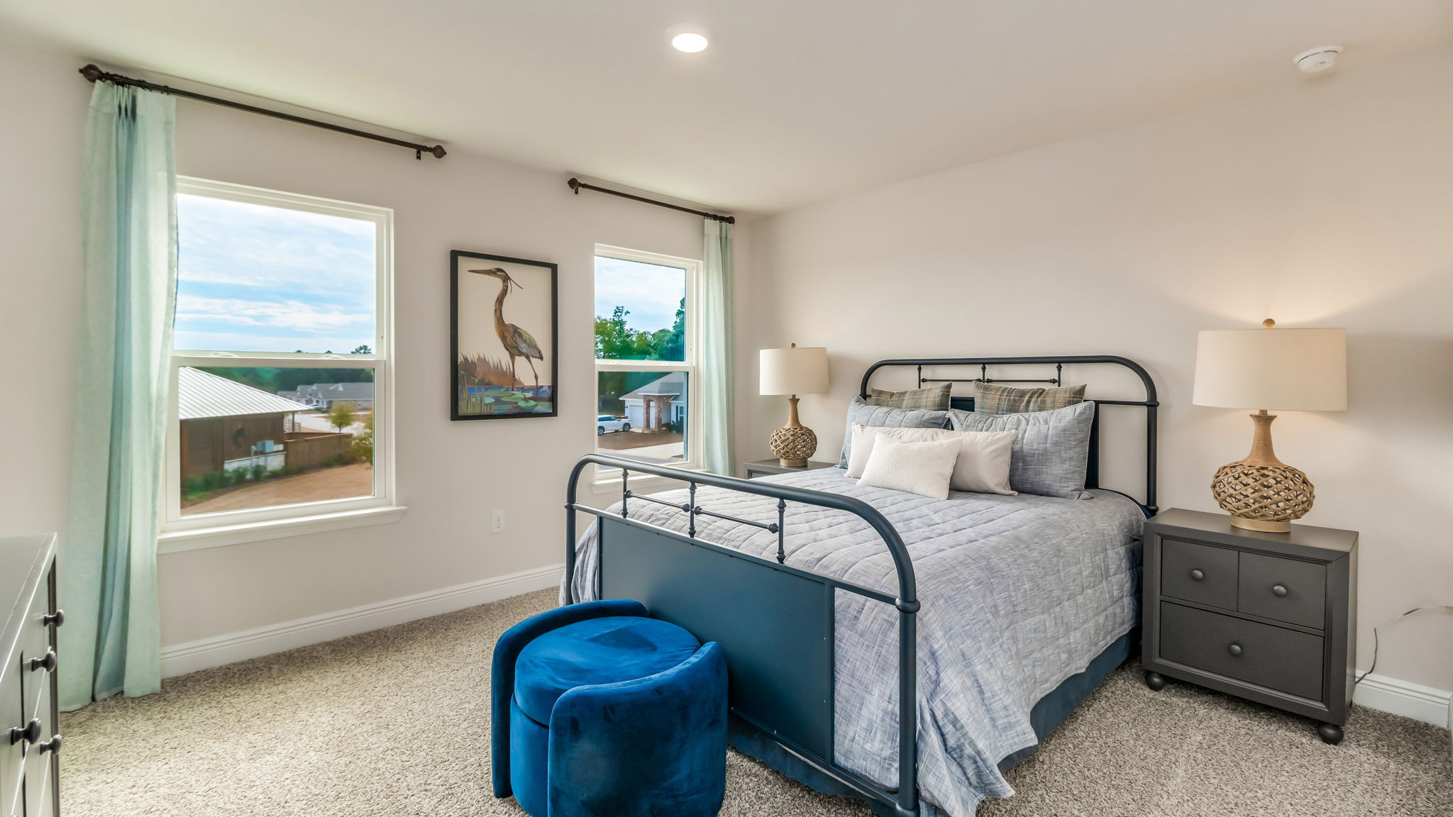 The Belfort floorplan guest bedroom one with two windows and carpet throughout
