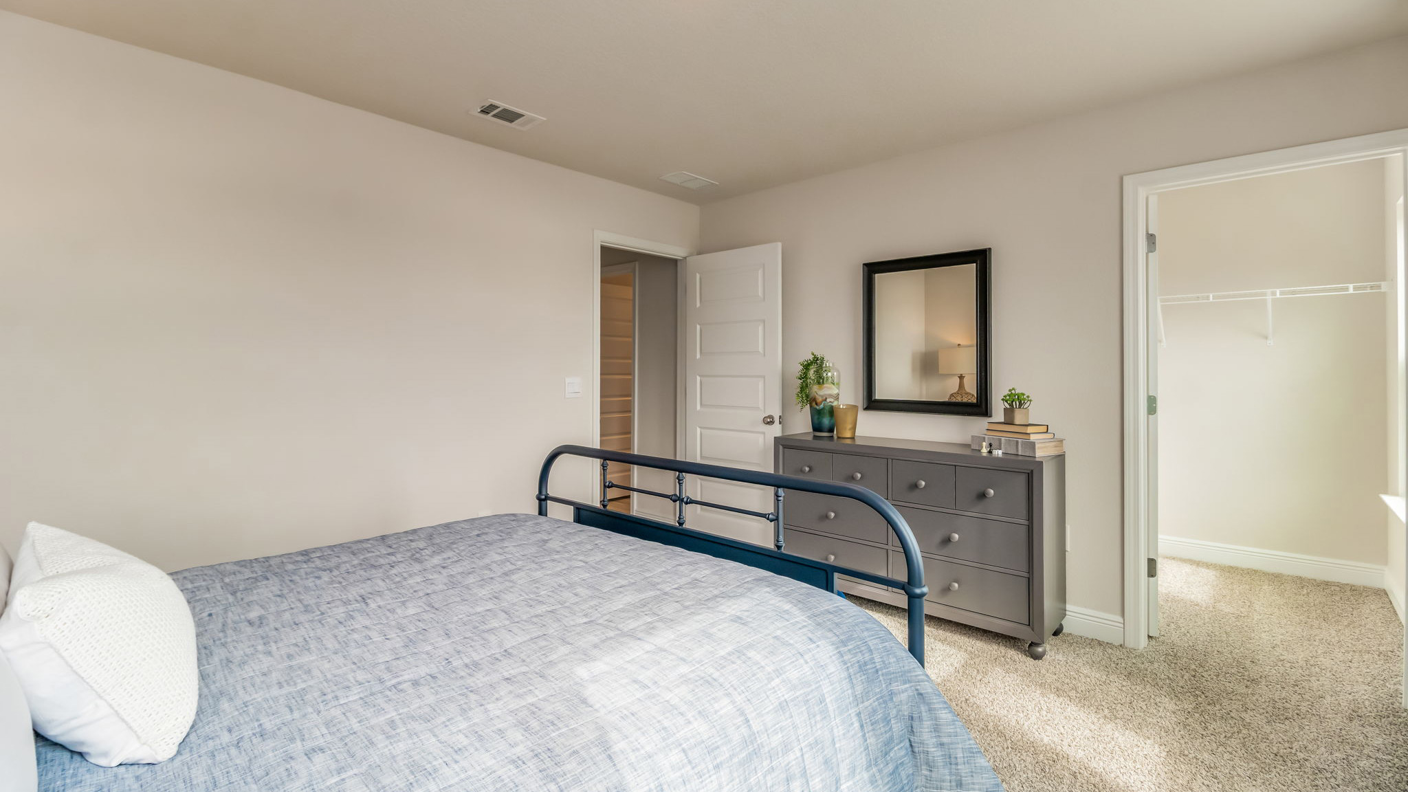 The Belfort floorplan guest bedroom one with two windows and carpet throughout