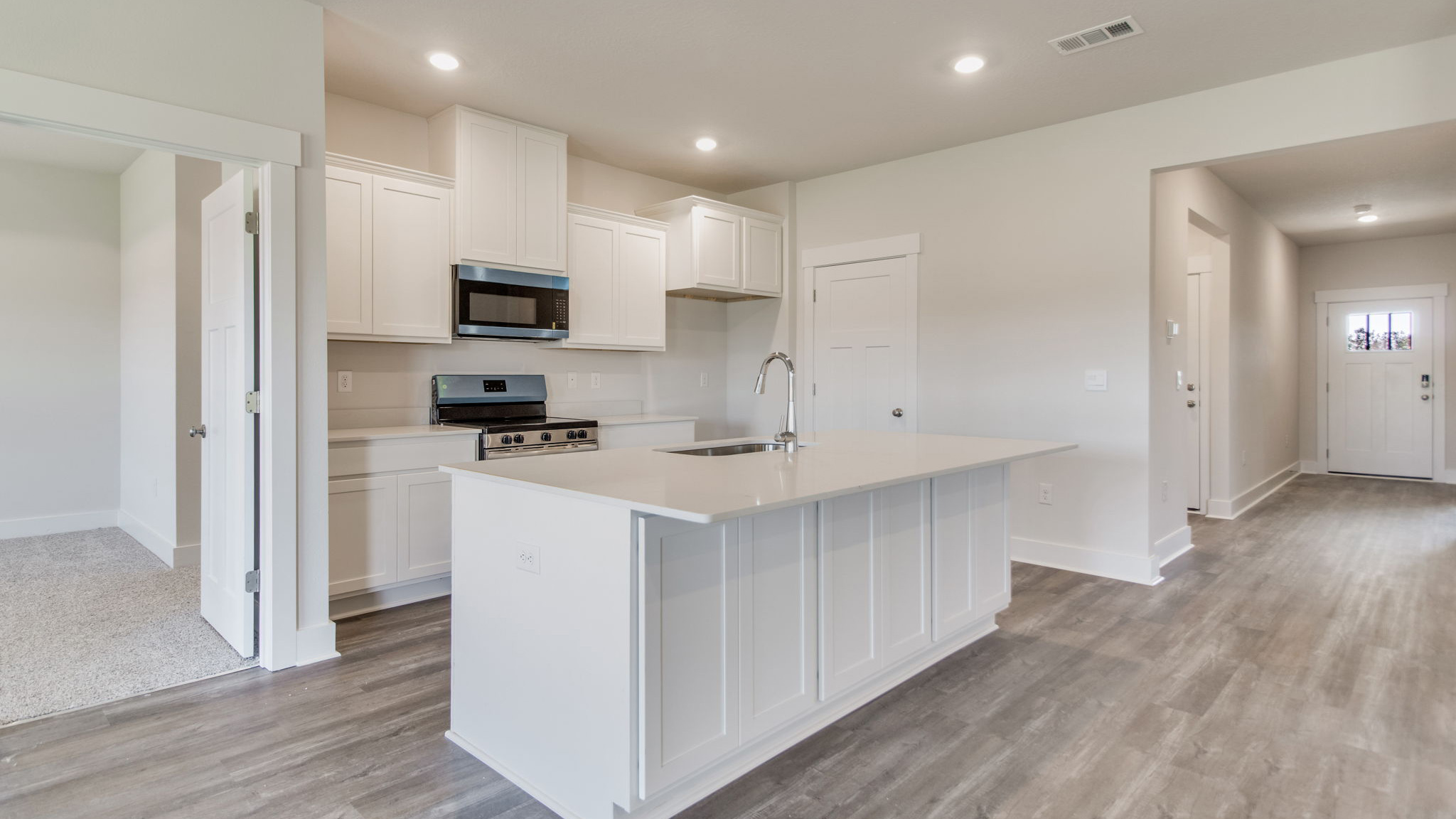 The Lamar floorplan kitchen with quartz countertops and stainless-steel appliances