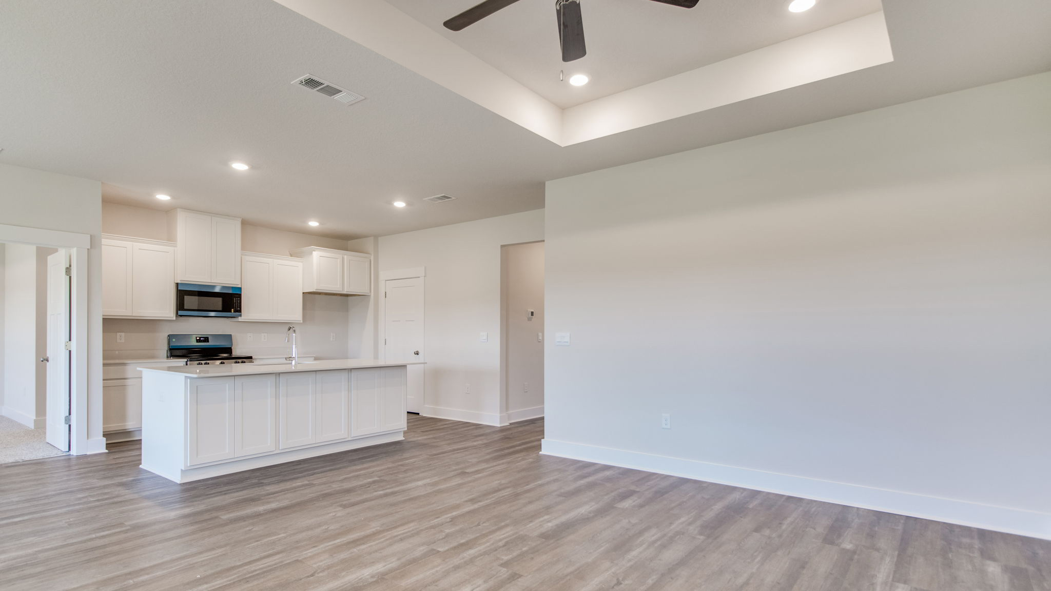 The Lamar floorplan open concept kitchen and living room with EVP flooring throughout