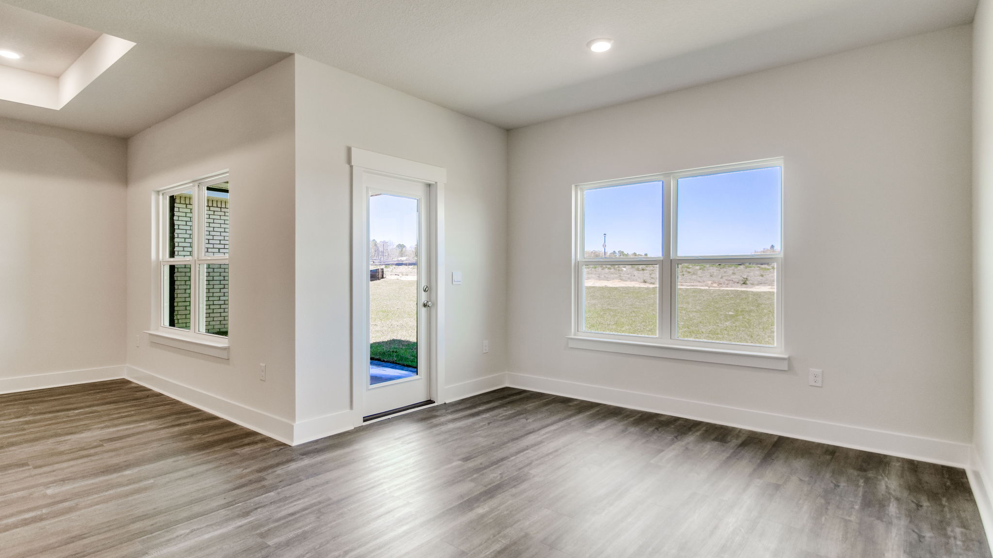 The Lamar floorplan open concept dining room with large window and EVP flooring throughout