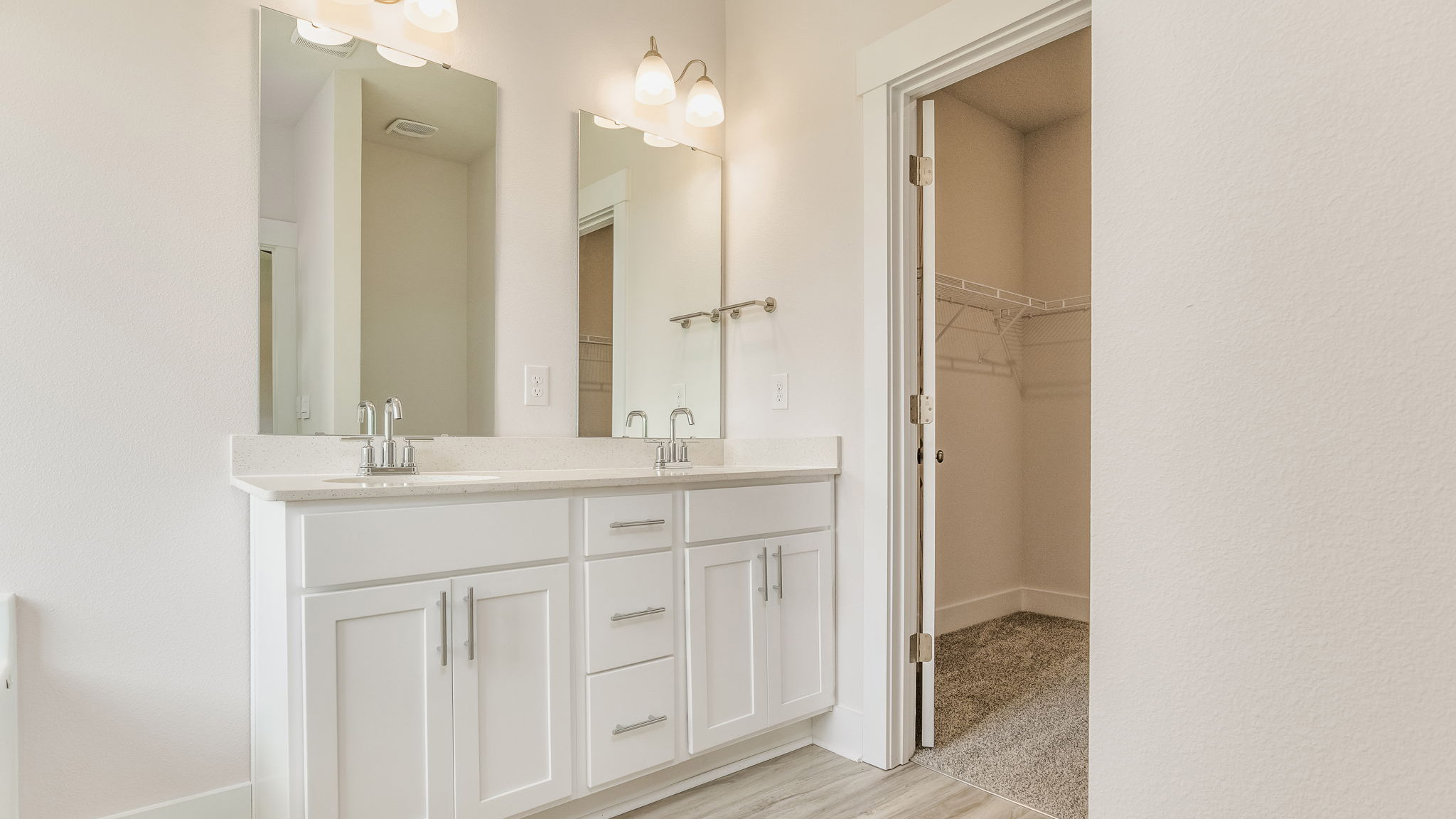 The Oakley floorplan primary bathroom with dual vanities and walk in closet